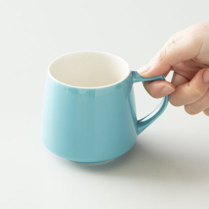Hand holding a blue mug on a light background #turquoise